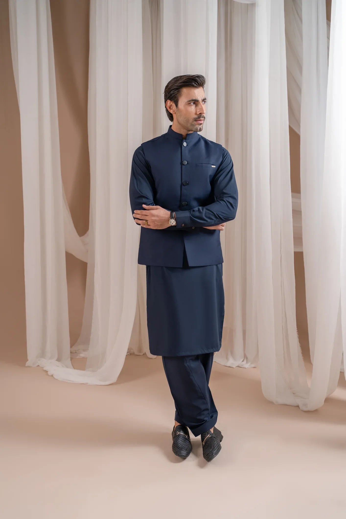 A man wearing a navy blue suiting buttoned waistcoat with a straight cut design.