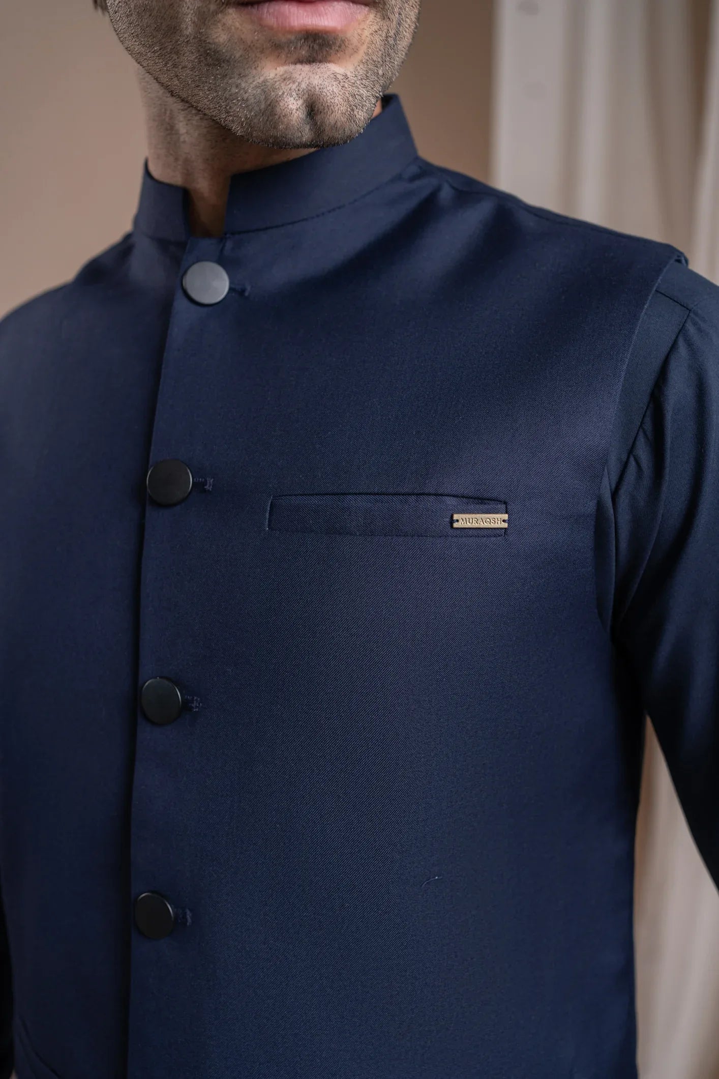 A man wearing a navy blue suiting buttoned waistcoat with a straight cut design.