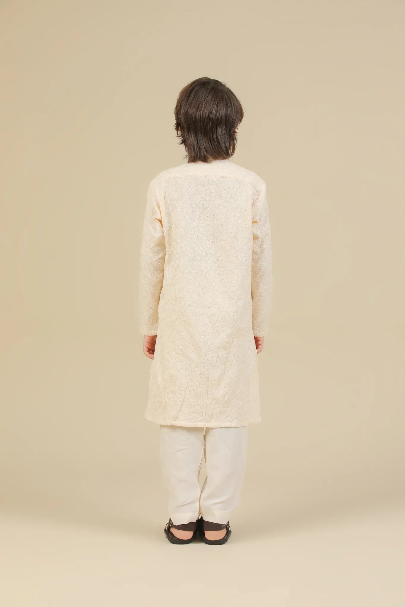 Child wearing a bosky white raw silk embroidered kurta trouser on a beige background