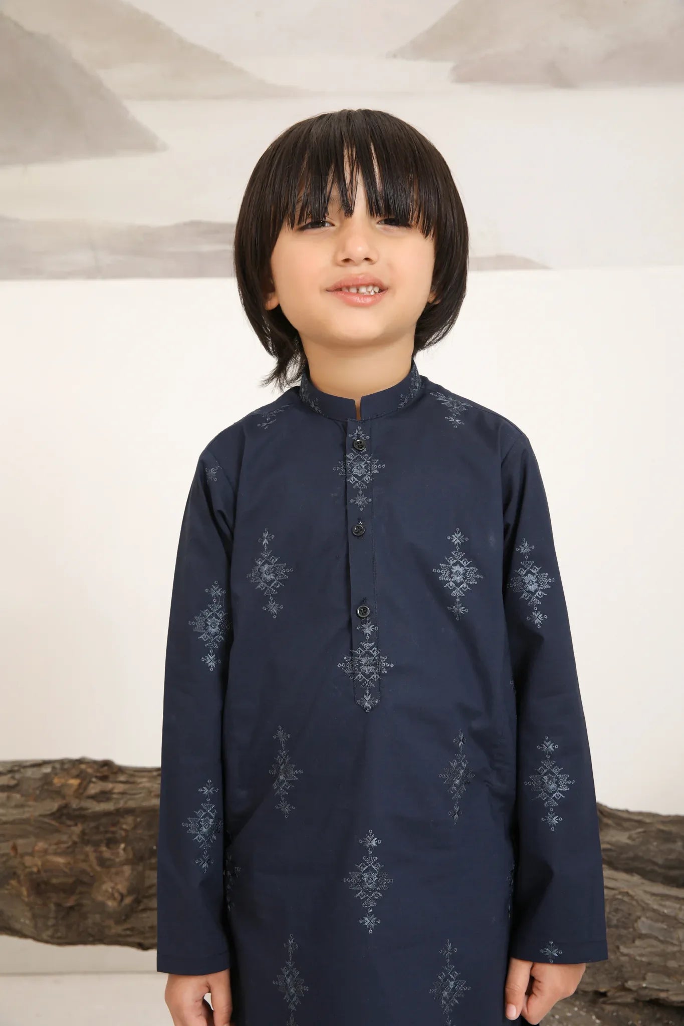 A child wearing a navy blue cotton embroidered kurta trouser