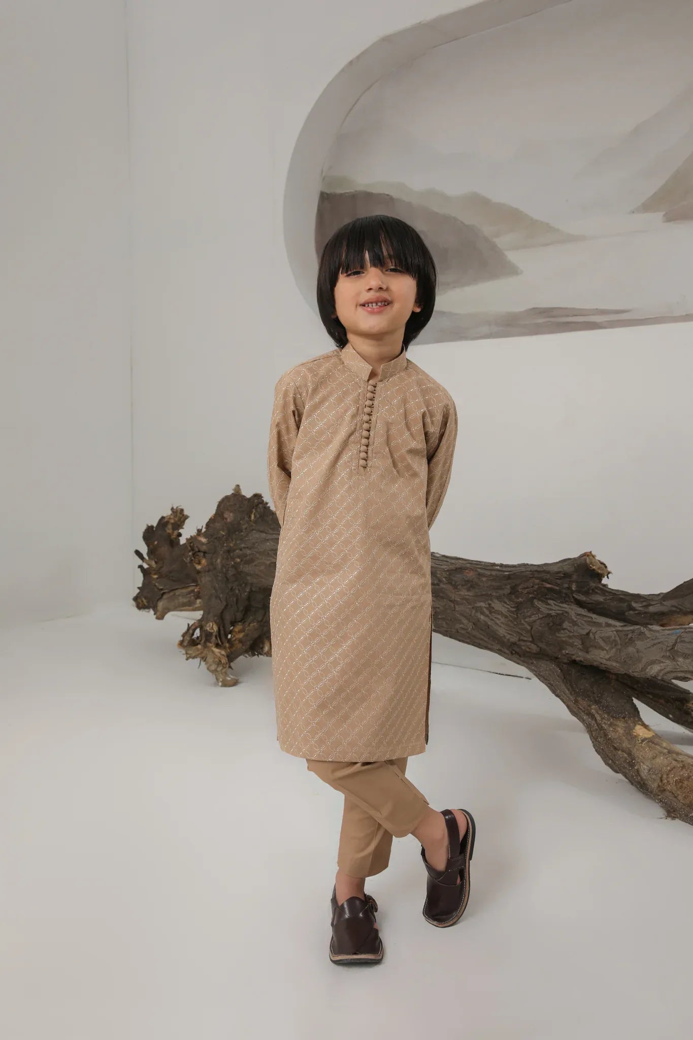 A child wearing a camel embroidered cotton kurta and trouser with a mandarin collar.