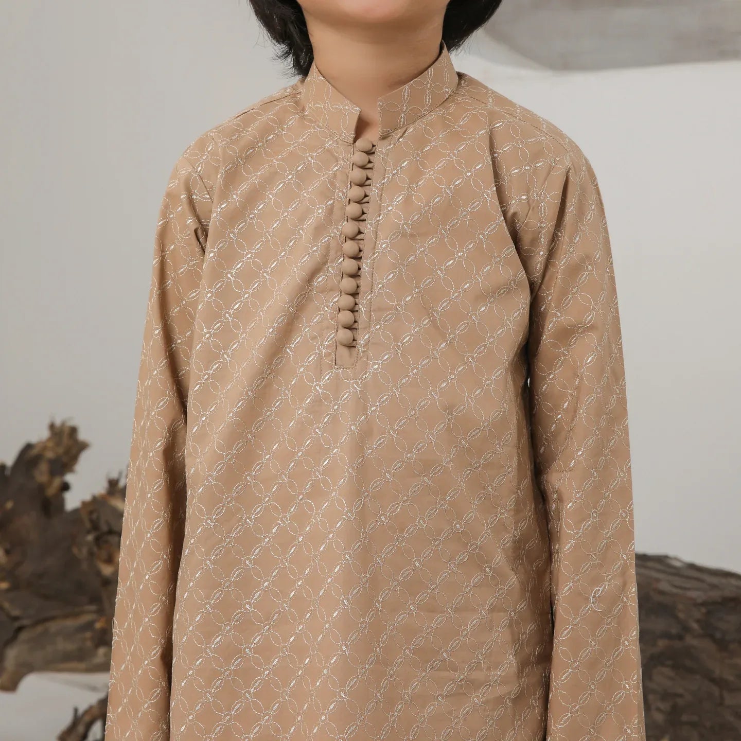 A child wearing a camel embroidered cotton kurta and trouser with a mandarin collar.