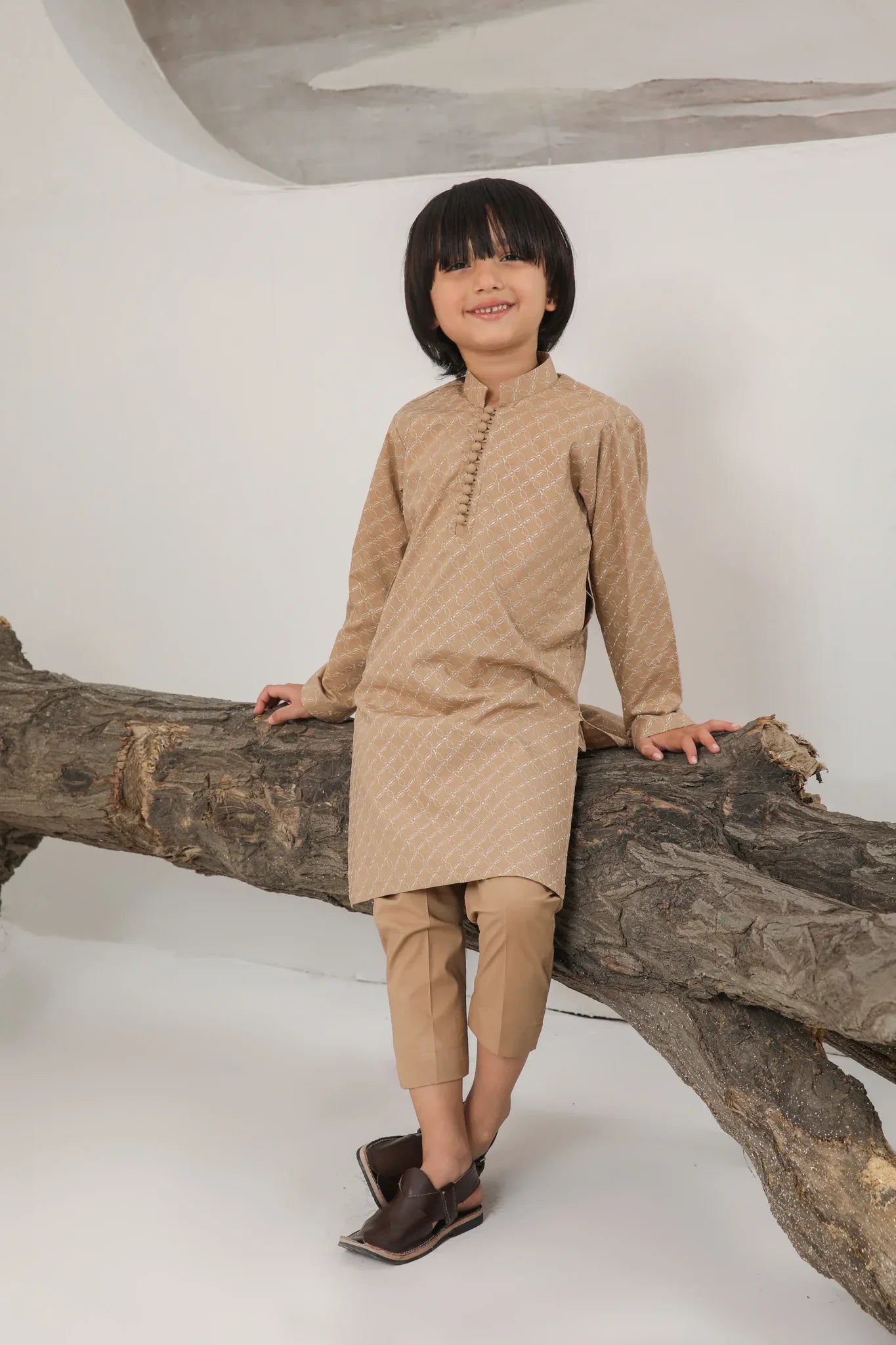 A child wearing a camel embroidered cotton kurta and trouser with a mandarin collar.