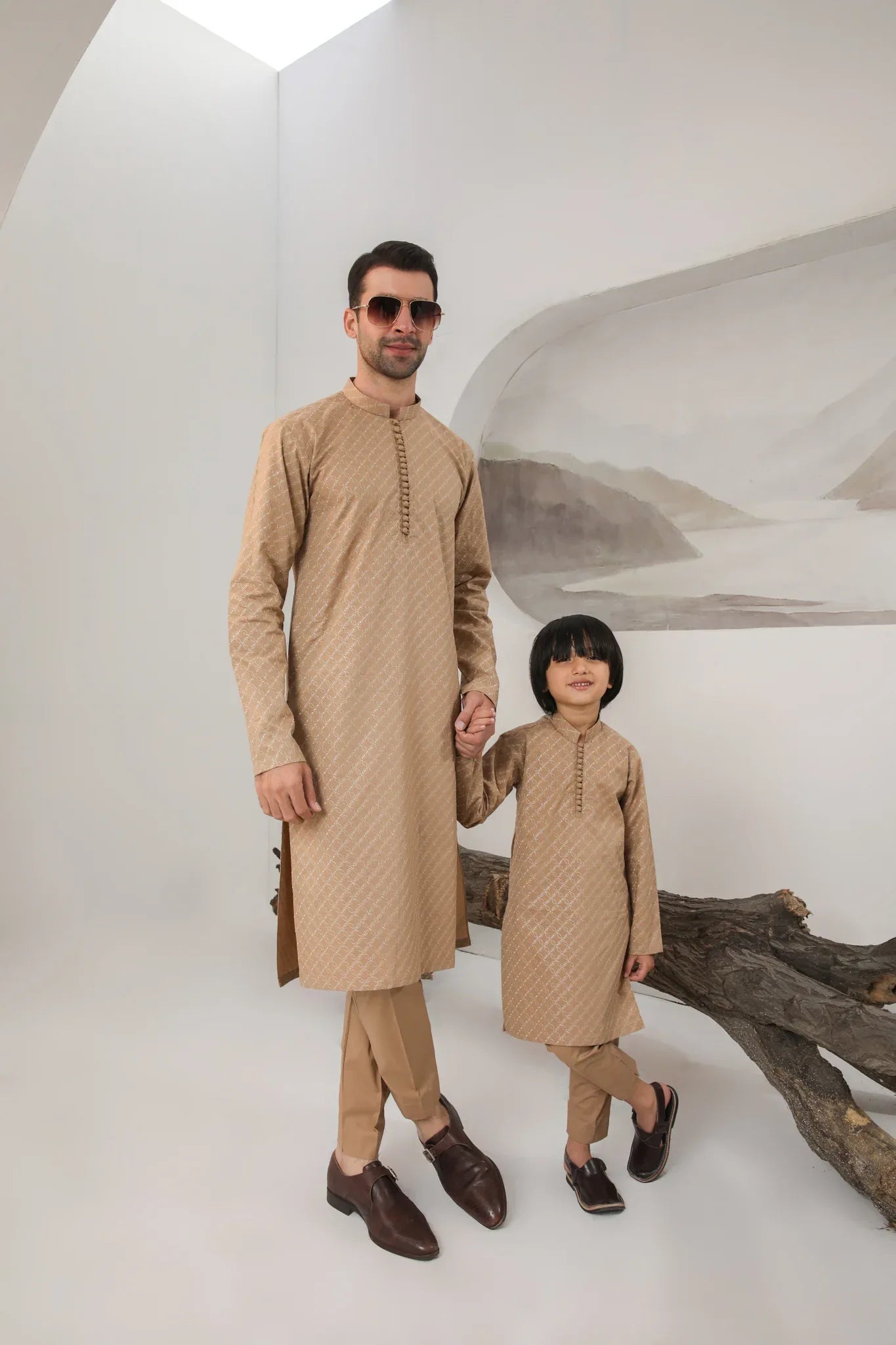 A child wearing a camel embroidered cotton kurta and trouser with a mandarin collar.