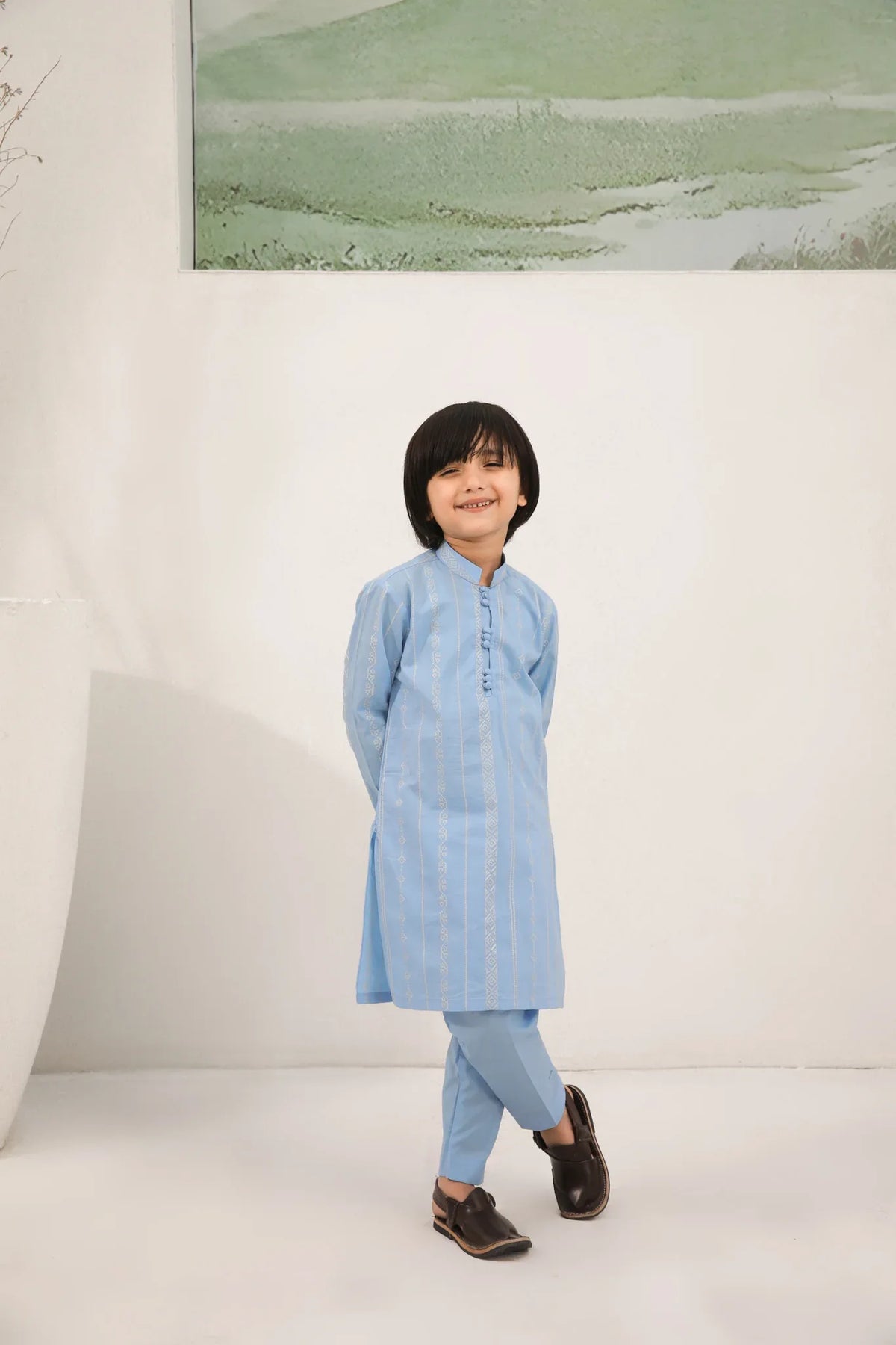 A child wearing a sky blue cotton embroidered kurta trouser