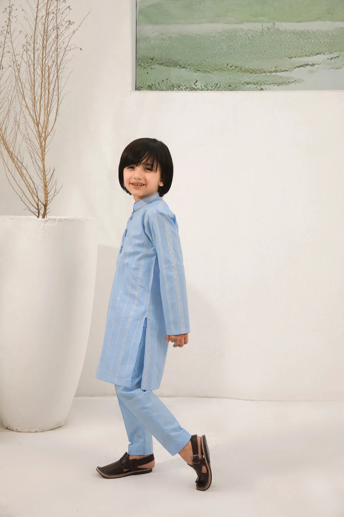 A child wearing a sky blue cotton embroidered kurta trouser