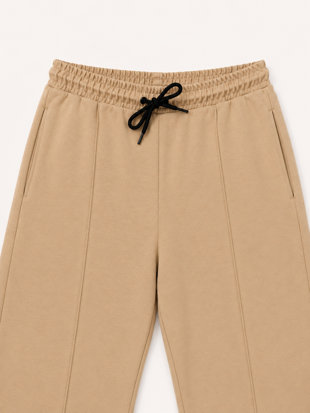 Beige pants with a black drawstring on a white background
