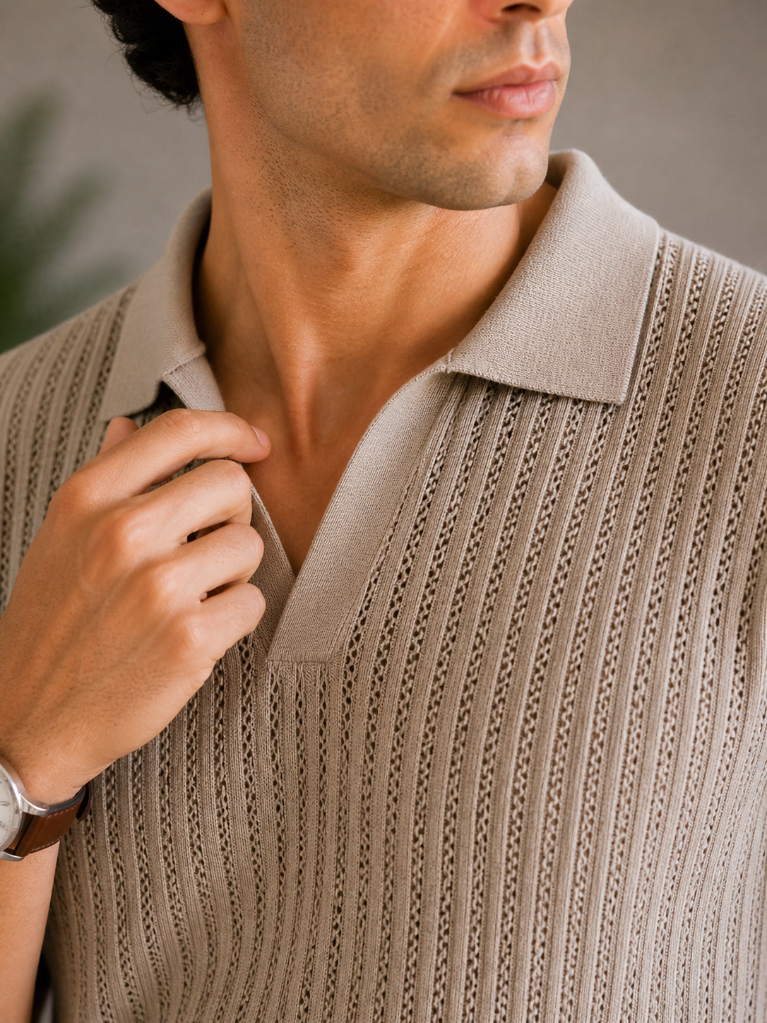 Man wearing a beige knitted sweater against a neutral background