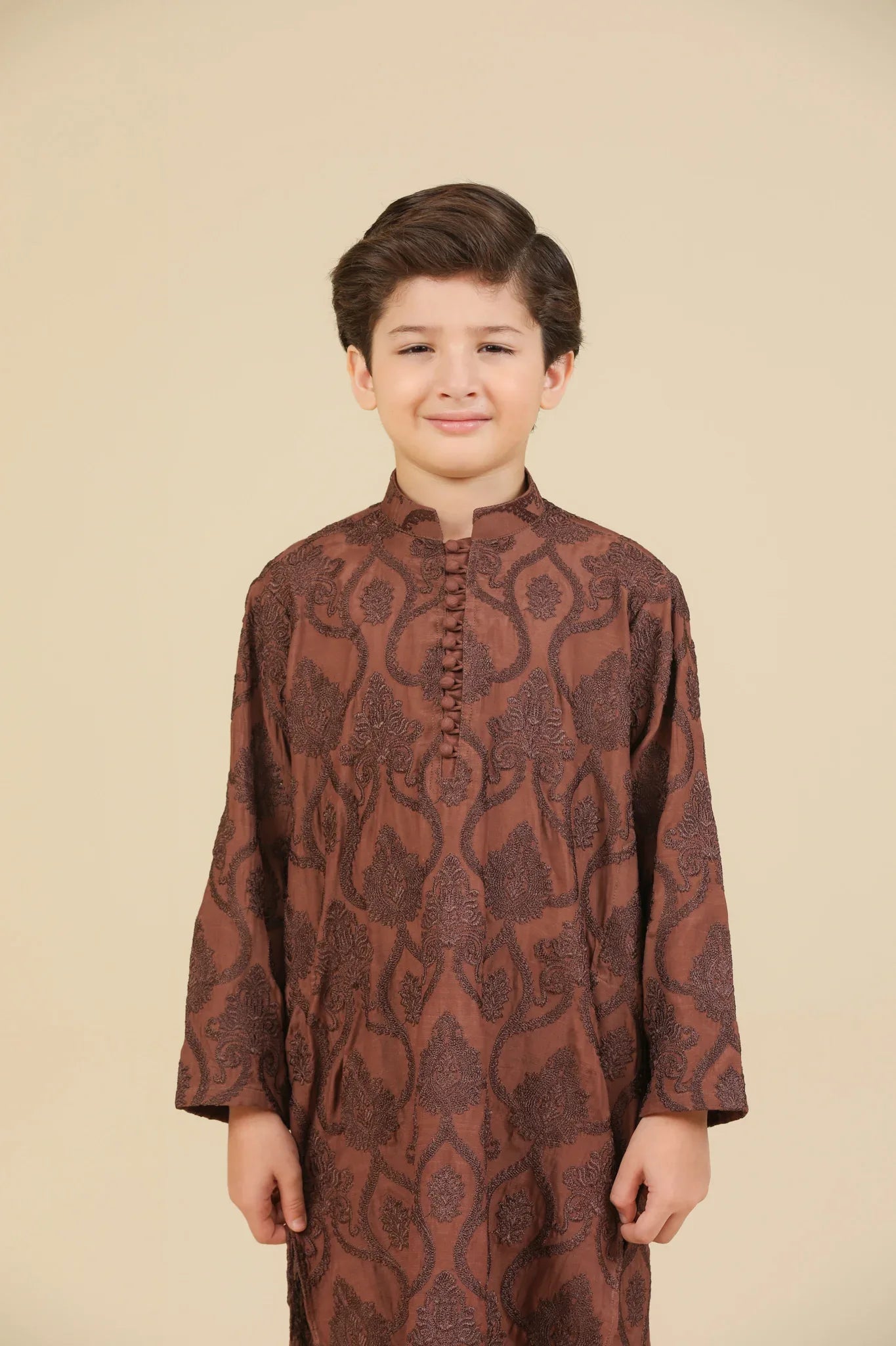Child wearing a cocoa brown raw silk embroidered kurta with pajama on a beige background