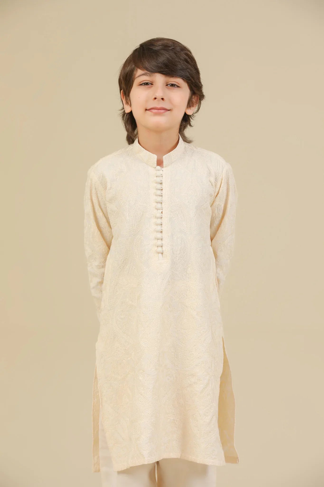 Child wearing a bosky white raw silk embroidered kurta trouser on a beige background