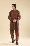 Man wearing a cocoa brown raw silk embroidered kurta trouser against a beige background