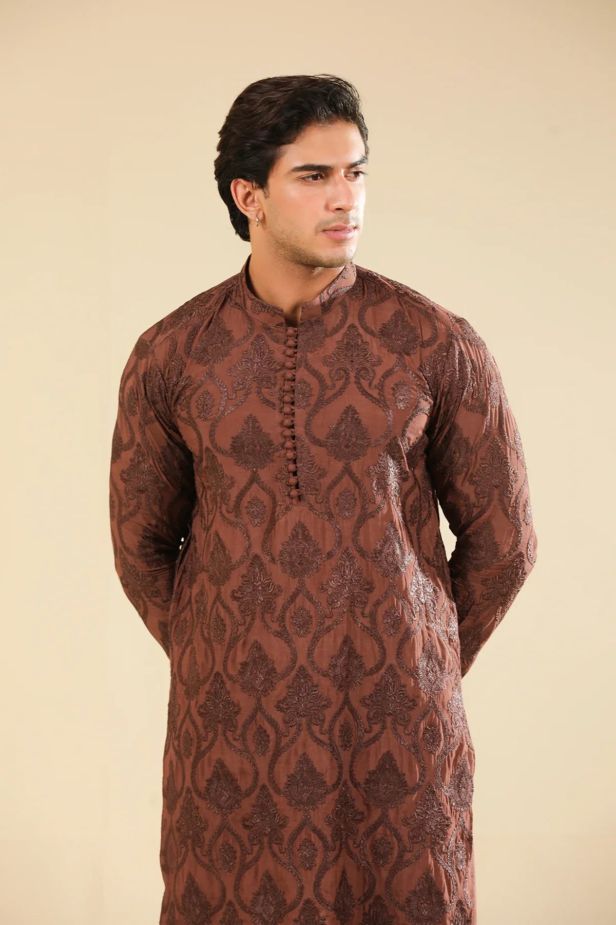 Man wearing a cocoa brown raw silk embroidered kurta trouser against a beige background